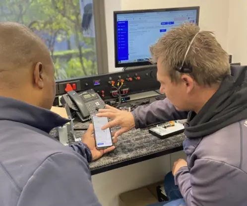 Technicians reviewing job updates on a mobile phone