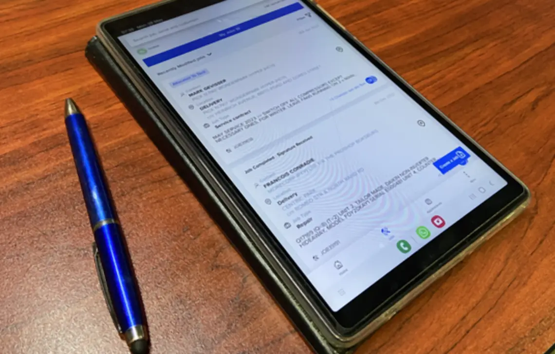 The ServCraft job list on a tablet, next to a pen
